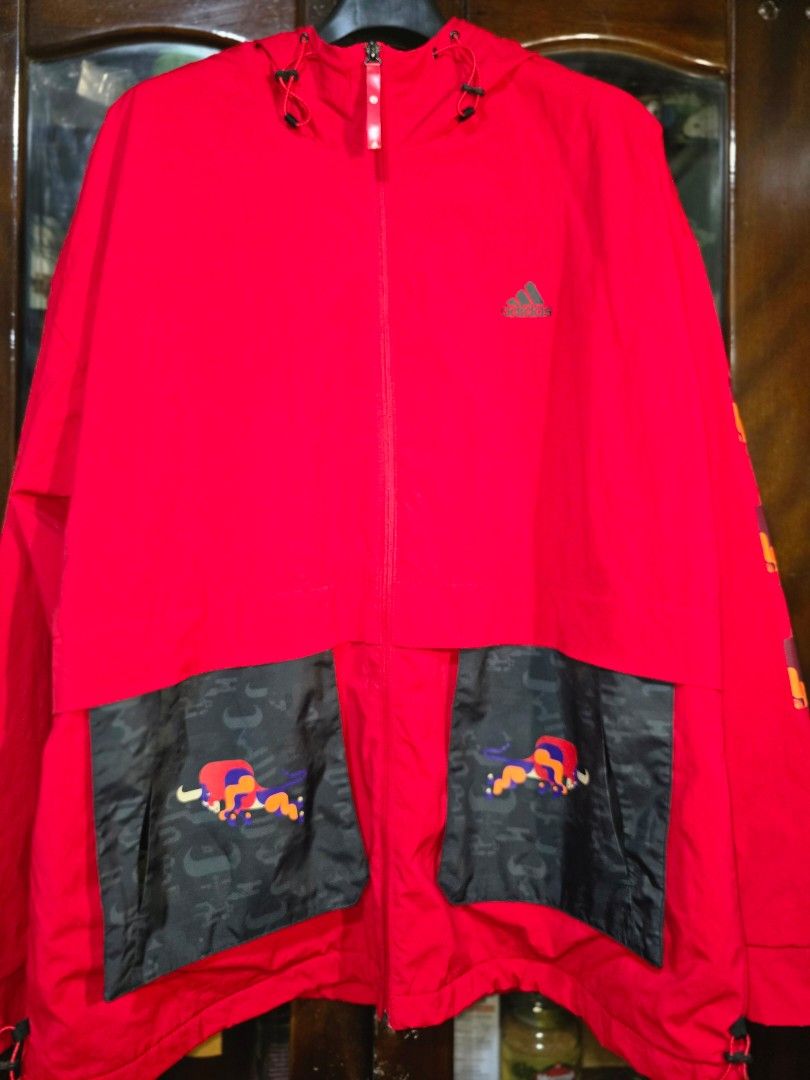 Adidas Red Jacket with Chinese New Year Graphics (Category: Coats, Jackets and Outerwear) located in Baguio. Submitted by genesisomega (Listing ID 1458966358, Image 2). Description: - Vibrant bright red Adidas jacket - Unique Chinese New Year graphic design on pockets - Classic Adidas logo on the chest - Adjustable drawstrings on hood and hem - Full zipper closure - Dimes 27 x 32 - Ideal for everyday casual wear ✨ PLEASE READ BEFORE BUYING! ✨ 👕 