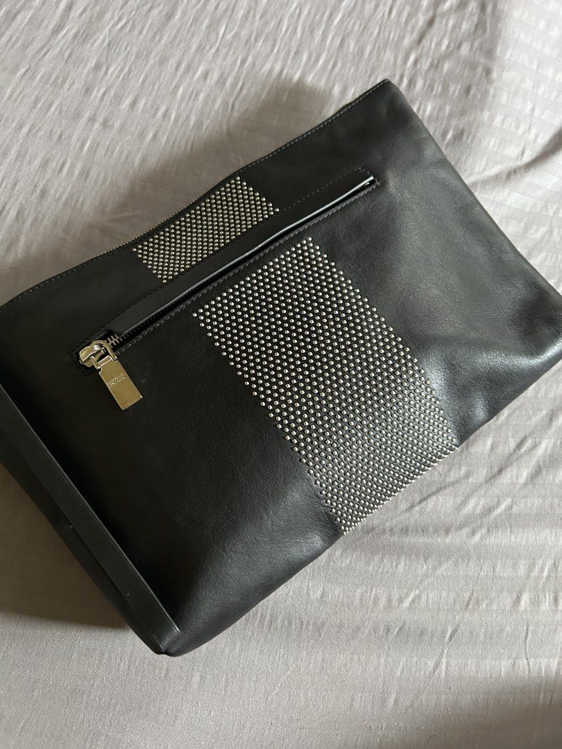 (Authentic) Alexander McQueen Black Leather Studded Clutch (Category: Luxury Bags & Wallets) located in Carigara. Submitted by abiealberca (Listing ID 1458934601, Image 1). Description: - Authentic Alexander McQueen clutch - Genuine black leather (Calf Skin) - Striking silver stud detailing in a striped pattern - Secure skull zipper closure with branded pull tab - Interior label confirms 'Made in Italy' and date code - Comes with original dust ba