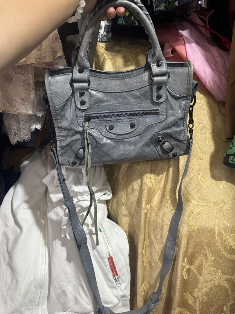 Balenciaga City Bag Grey Leather (Category: Luxury Bags & Wallets) located in Manila. Submitted by wildbear.e10374 (Listing ID 1458915480, Image 2). Description: - Authentic Grey Balenciaga City bag - Made from soft, genuine leather - Front zip pocket for easy access - Secure top zip closure - Braided top handles - Detachable long strap for shoulder or crossbody wear - Shows some signs of wear on leather and strap, consistent with pre-loved condi
