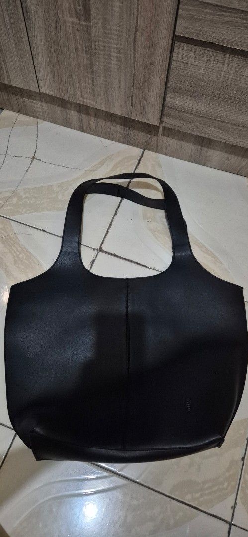 Black Leather Tote Bag (Category: Tote Bags) located in Pasig City. Submitted by yelther (Listing ID 1458956590, Image 1). Description: Straightforward DVL Nara Tote bag - black vegan leather tote bag - Secure magnetic snap closure - Spacious interior for all your essentials - Ideal for everyday use - used once, no flaws or markings mop: gcash, bdo delivery c/o buyer.