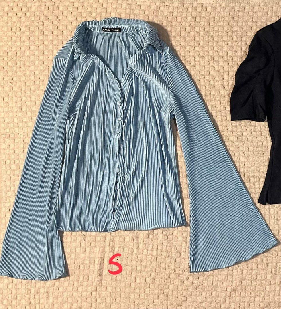 Blue Pleated Bell Sleeve Button Up Shirt (Category: Tshirts & Polo Shirts ) located in Mandaluyong City. Submitted by hopeworldplane (Listing ID 1458990789, Image 2). Description: - Light blue pleated shirt - Long bell sleeves - Button-up front with collar - Versatile styling: tuck in, wear open - Ideal for night out or casual wear - Flowy and stylish design.