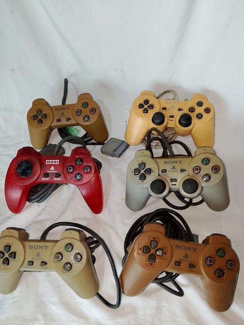 Bundle of 6 Sony PlayStation 1 Controllers (Category: PlayStation) located in Quezon City. Submitted by jpnvintageonline (Listing ID 1458904996, Image 2). Description: - Bundle of 6 PlayStation 1 controllers - Includes original Sony DualShock and one Hori controller - Various colors: tan, yellow, red, and grey - All controllers come with cords - Ideal for retro gaming sessions - Great value bundle.