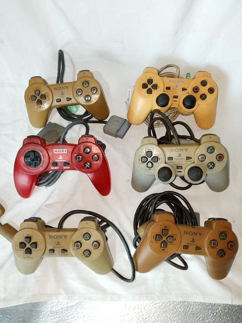 Bundle of 6 Sony PlayStation 1 Controllers (Category: PlayStation) located in Quezon City. Submitted by jpnvintageonline (Listing ID 1458904996, Image 3). Description: - Bundle of 6 PlayStation 1 controllers - Includes original Sony DualShock and one Hori controller - Various colors: tan, yellow, red, and grey - All controllers come with cords - Ideal for retro gaming sessions - Great value bundle.