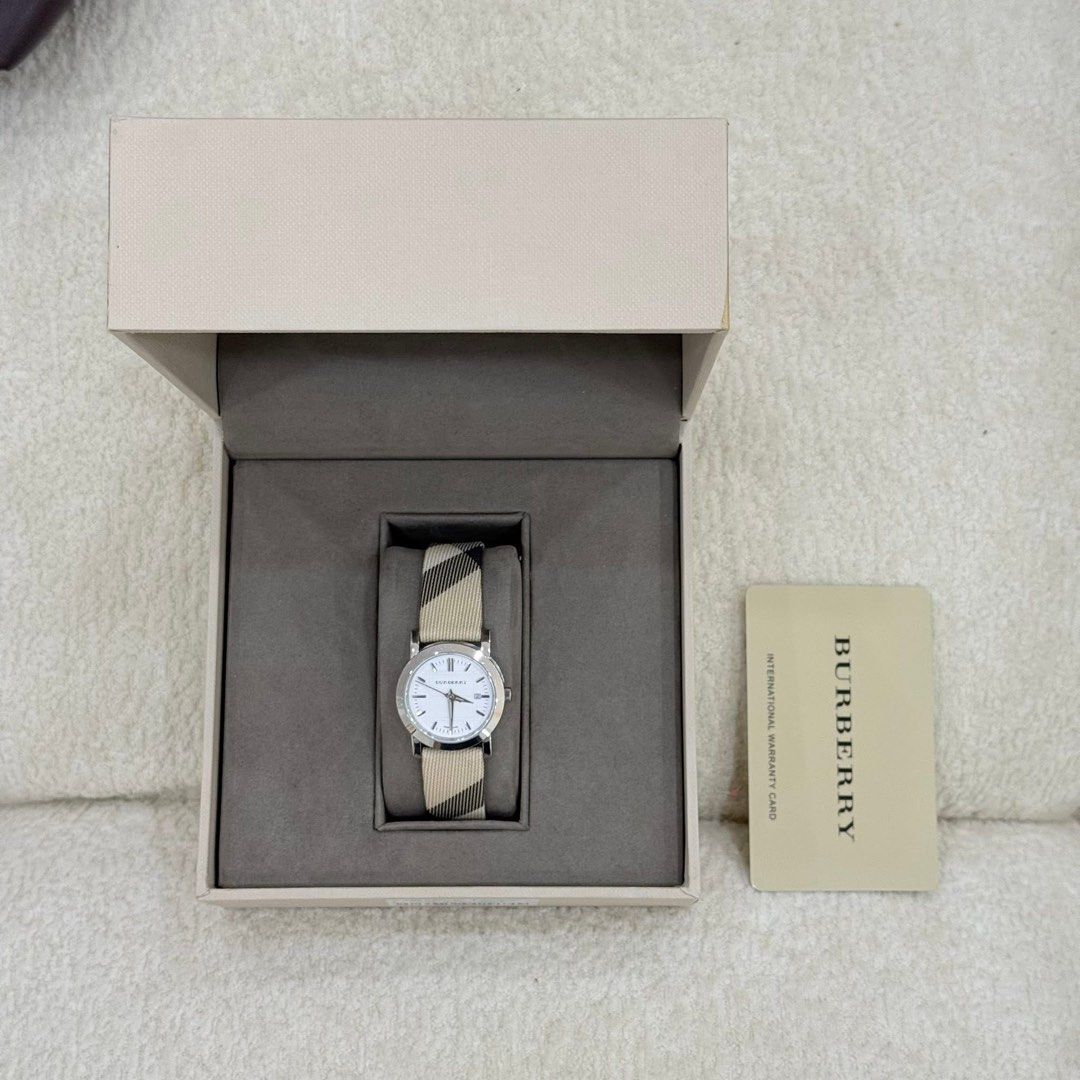 Burberry Watch with Classic Check Strap (Category: Luxury Watches) located in San Leonardo. Submitted by iluvkopiii (Listing ID 1458922833, Image 1). Description: Burberry Swiss Made Quartz Watch featuring the iconic Nova Check textile strap and a classic silver dial. Complete with original box and authenticity card. ₱15,000 only.