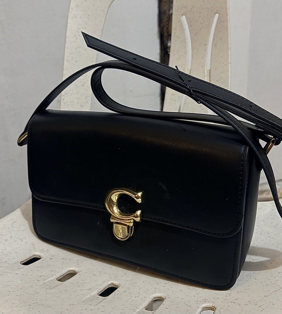 Coach Black Leather Shoulder Bag with Gold Hardware (Category: Luxury Bags & Wallets) located in Manila. Submitted by gellybeanss2002 (Listing ID 1459083632, Image 1). Description: - Genuine black leather shoulder bag - Elegant gold 'C' clasp closure - Multiple interior compartments for organization - Soft tan suede-like lining - Adjustable strap for comfortable wear.