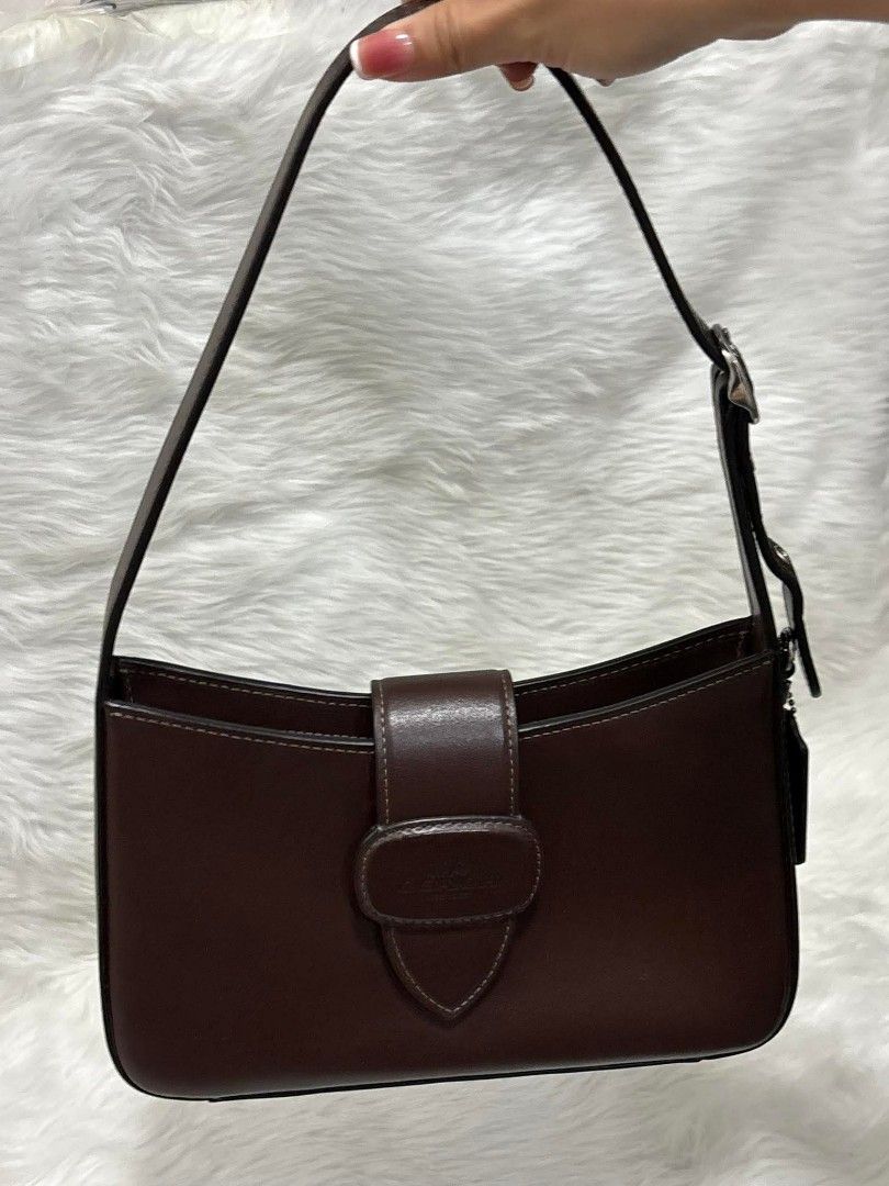 Coach Eliza Shoulder Bag (Brown) (Category: Luxury Bags & Wallets) located in Manila. Submitted by seresa_04 (Listing ID 1458902704, Image 1). Description: - Classic brown leather shoulder bag by Coach - Simple and chic design - Interior zippered pocket - Adjustable strap for comfort - Ideal for everyday use - Perfectly fits your essentials.