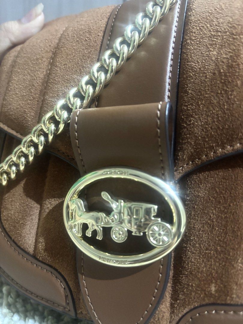 Coach Georgie Saddle Bag with Linear Quilting (Category: Luxury Bags & Wallets) located in Manila. Submitted by ourcams0701 (Listing ID 1459022157, Image 2). Description: - Bought for 26k -No dustbag - Brown Coach shoulder bag - Mix of suede and pebbled leather - Gold chain strap - Classic Coach horse and carriage logo - Comes with a Coach leather tag - Versatile for everyday or evening wear.