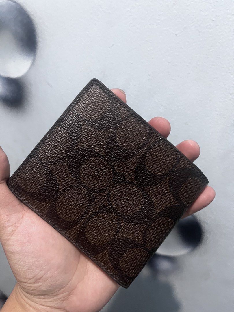 Coach Signature C Monogram Bifold Wallet Brown (Category: Luxury Bags & Wallets) located in Baguio. Submitted by lattethrift21 (Listing ID 1458904879, Image 2). Description: - Authentic Brown Coach Bifold Wallet - Signature "C" Monogram Pattern All Over - Black Leather Interior - Multiple Card Slots - Bill Compartment - Gold "Coach New York" Logo Stamped Inside - Classic and Stylish Everyday Accessory.