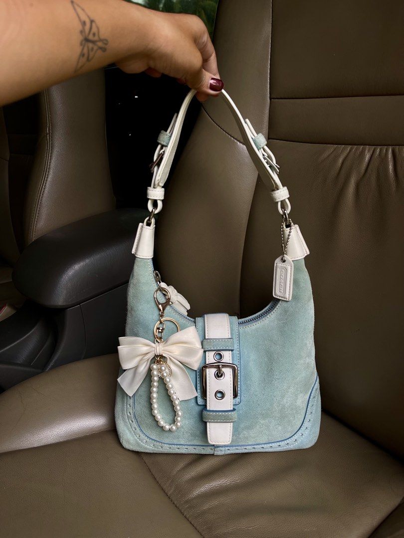 Coach Suede Hampton satchel Hobo Bag Light Blue (Category: Luxury Bags & Wallets) located in Dumaguete. Submitted by braveforest-2a12 (Listing ID 1458929993, Image 2). Description: - Light blue suede Coach hobo bag - White leather trim and buckle detail - Comes with original care booklet and cleaning kit - Adorable pearl and ribbon charm attached - Secure zipper closure - Ideal for everyday use.