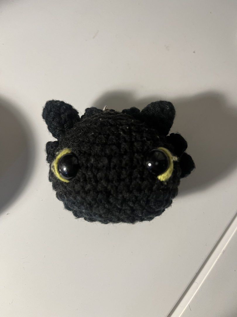 Crocheted Toothless Dragon Keychain (Category: Character Goods) located in Manila. Submitted by gentlefish_473ecf (Listing ID 1459004440, Image 1). Description: - Handmade crocheted keychain featuring Toothless from How to Train Your Dragon. - Classic black color with striking yellow eyes. - Comes with a durable metal keyring. - Ideal accessory for your bags, backpacks, or keys. - A unique and charming gift for fans!.