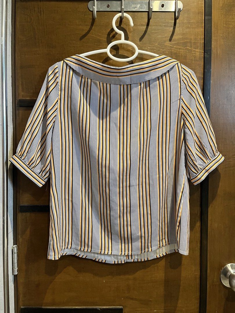 Emu Striped Button-Up Blouse with Collar (Category: Blouses) located in Las Pinas. Submitted by francesaly (Listing ID 1458974732, Image 3). Description: - Cute striped blouse from Emu - Features a wide collar and button-up front - Short puff sleeves - Vertical stripes in black, white, and orange-yellow - Versatile for casual or dressed-up occasions - Easy to pair with jeans or skirts.