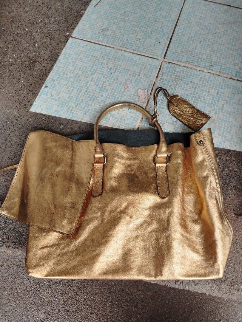 Gold Metallic leather Tote Bag with Pouch (Category: Tote Bags) located in Manila. Submitted by purediamond888 (Listing ID 1458965911, Image 2). Description: - Stunning shiny gold tote bag - Generously sized for all your essentials - Includes a matching small pouch - Beautiful leather with a nice sheen - Sturdy and reliable handles - Versatile for everyday wear or a night out.