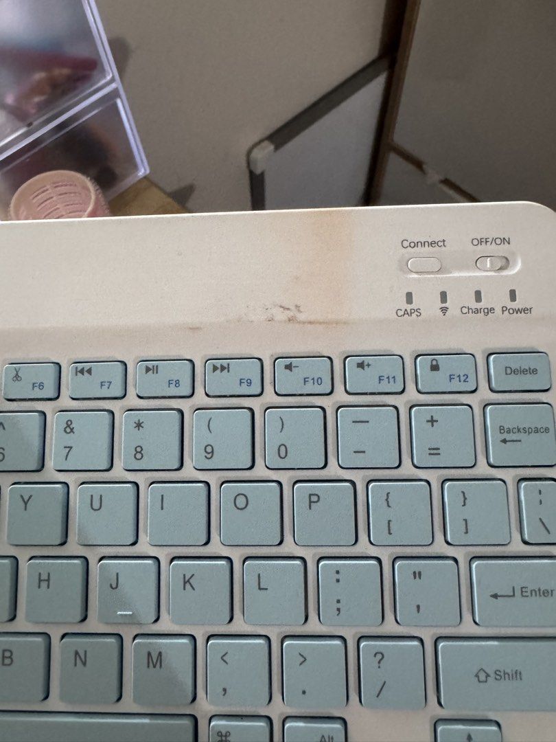 GOOJODOQ Bluetooth Keyboard White Light Blue Keys (Category: Computer Keyboard) located in Manila. Submitted by redvelvetcheesecake13 (Listing ID 1458907061, Image 2). Description: - Has a stain at the top part - Works perfectly - Features indicator lights for CAPS Lock, Charging, and Power status - Compatible with Android, iOS, and Windows devices .