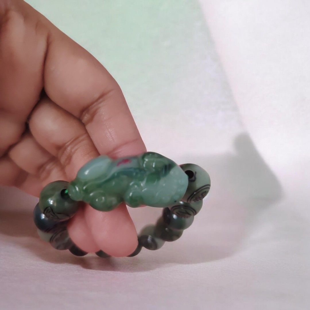 Green Jadeite Bracelet with Carved Charm (Category: Bracelets) located in Antipolo. Submitted by goodsinger (Listing ID 1458969183, Image 1). Description: - Genuine green jadeite beads - Unique carved charm (mythical creature/animal) - Natural sheen and varied green hues - Comfortable elastic band for easy wear - Perfect addition to any jewelry collection.