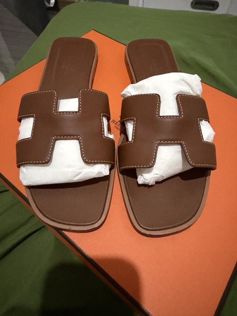 Hermes Oran Slippers - Authentic (Category: Flats & Sandals) located in Manila. Submitted by thraciecapule (Listing ID 1458917594, Image 2). Description: - Comes with box, dust bag and paper bag - Authentic Hermes H sandals - Color: Brown - Material: Smooth leather - Features neat stitching - Includes original box and paper bag - Versatile for casual or dressed-up looks RFS: got pregnant after buying, feet changed size. .