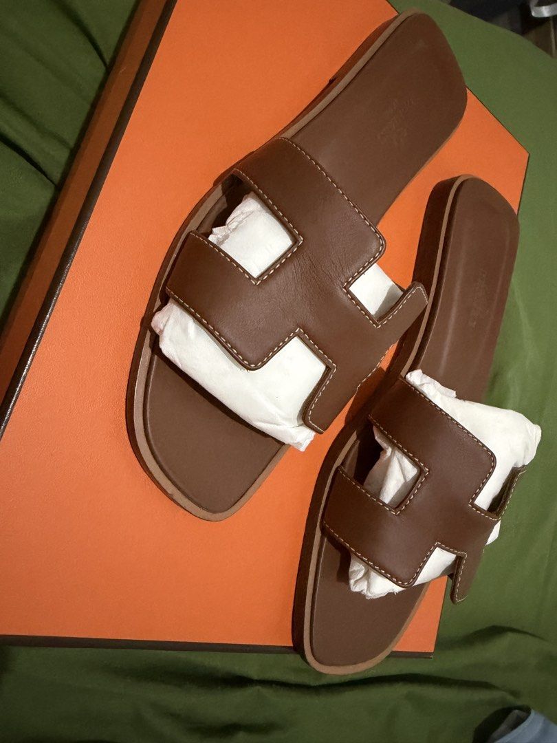 Hermes Oran Slippers - Authentic (Category: Flats & Sandals) located in Manila. Submitted by thraciecapule (Listing ID 1458917594, Image 1). Description: - Comes with box, dust bag and paper bag - Authentic Hermes H sandals - Color: Brown - Material: Smooth leather - Features neat stitching - Includes original box and paper bag - Versatile for casual or dressed-up looks RFS: got pregnant after buying, feet changed size. .