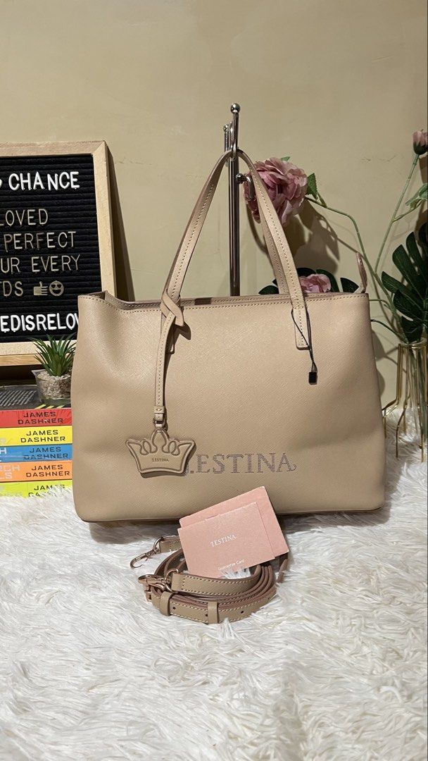 Jestina Beige Leather Tote Bag (Category: Tote Bags) located in Mati. Submitted by CrestChancebyIFT (Listing ID 1459026327, Image 1). Description: -top Korean bag brand - Beige leather tote bag from Jestina - Adorned with a crown charm and embossed logo - Comes with a detachable shoulder strap - Interior features a zippered pocket and card slots - Minor scuffs on the exterior - Ideal for everyday use.