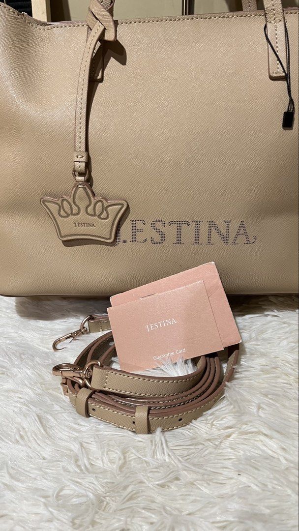 Jestina Beige Leather Tote Bag (Category: Tote Bags) located in Mati. Submitted by CrestChancebyIFT (Listing ID 1459026327, Image 2). Description: -top Korean bag brand - Beige leather tote bag from Jestina - Adorned with a crown charm and embossed logo - Comes with a detachable shoulder strap - Interior features a zippered pocket and card slots - Minor scuffs on the exterior - Ideal for everyday use.