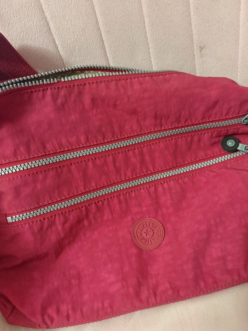 Kipling Red Nylon Crossbody Bag with Multiple Zips (Category: Cross-body Bags) located in Paranaque City. Submitted by aihp20 (Listing ID 1458923513, Image 1). Description: - Authentic Red Kipling Crossbody Bag - Durable Nylon Material - Three Zippered Compartments on the Front - Adjustable Strap with Metal Hardware - Kipling Logo Zipper Pulls - Ideal for Everyday Use - Spacious Enough for Your Essentials.
