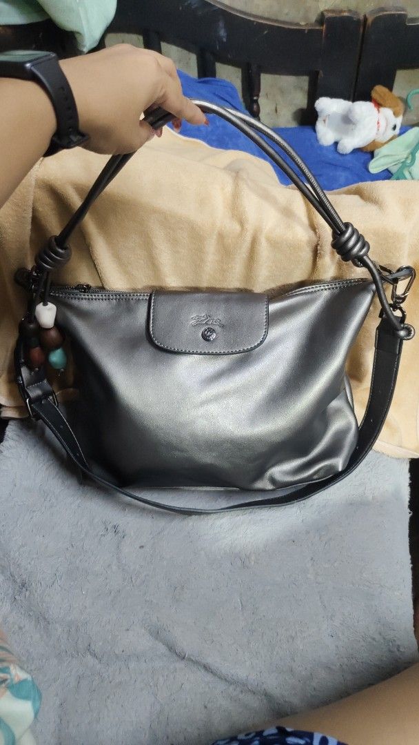 Longchamp "Le Pliage" Shoulder Bag - Metallic Grey (Category: Luxury Bags & Wallets) located in Antipolo. Submitted by robannrave98496 (Listing ID 1458927962, Image 2). Description: - Brand: Longchamp - Model: Le Pliage - Color: Metallic Grey - Closure: Snap and zip top - Features: Detachable strap, cute beaded charms on the side - Style: Shoulder bag - Condition: Great for everyday use - Interior: Plenty of space.