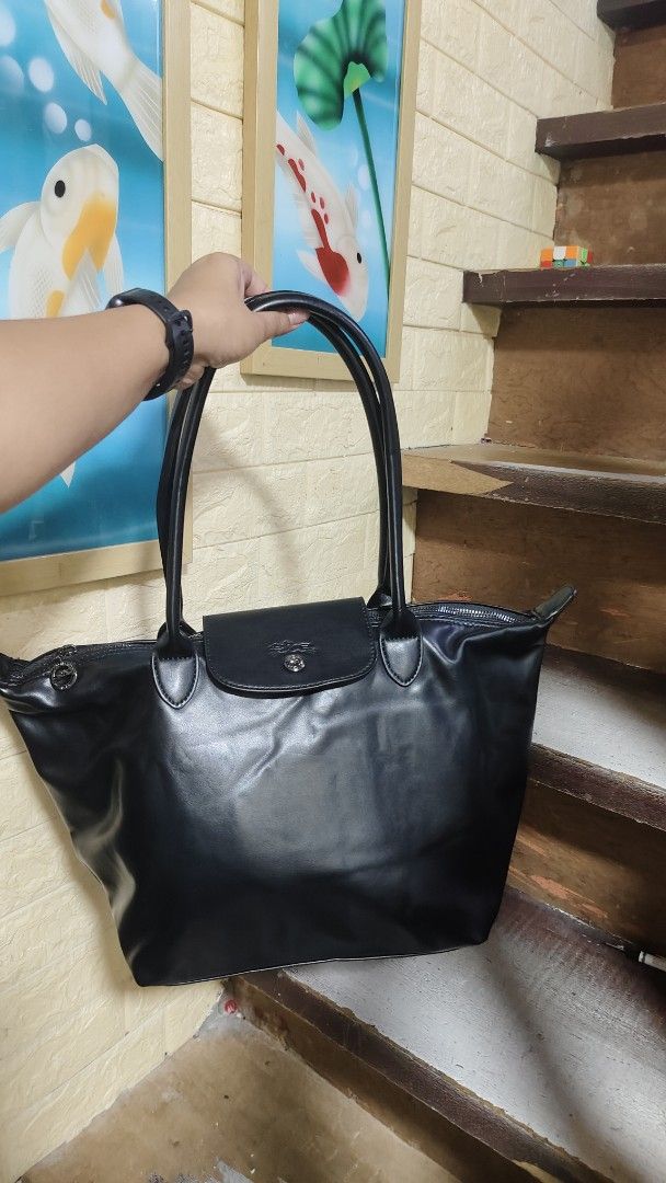 Longchamp Le Pliage Tote Bag Black Leather (Category: Luxury Bags & Wallets) located in Antipolo. Submitted by robannrave98496 (Listing ID 1458955115, Image 1). Description: - Classic black Longchamp tote bag - Made of leather - Signature Longchamp logo on snap closure - Interior features iconic Longchamp pattern - Secure top zipper closure - Comfortable, easy-to-carry handles - Ideal for everyday use.