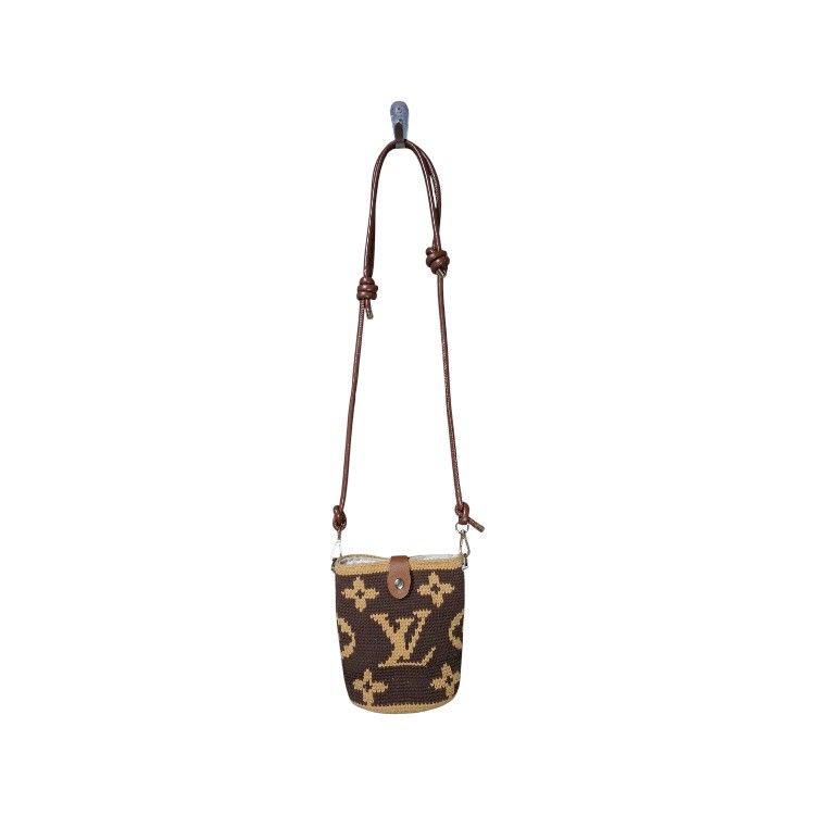 Louis Vuitton Monogram Crochet Bucket Bag (Category: Luxury Bags & Wallets) located in Leyte. Submitted by jpsrvd19 (Listing ID 1458995188, Image 1). Description: - Chic brown and tan crochet bucket bag - Features iconic LV monogram pattern - Genuine leather strap with adjustable knots - Secure small leather flap closure with snap button - Protective metal feet on the bottom - Ideal size for carrying your daily essentials.
