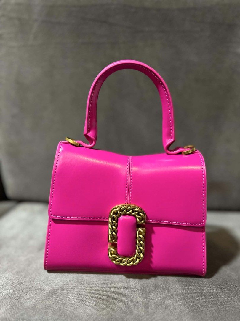 Marc Jacobs Pink Top Handle Bag with Gold Chain (Category: Luxury Bags & Wallets) located in Lipa City. Submitted by thyra06 (Listing ID 1458895106, Image 2). Description: - Vibrant bright pink Marc Jacobs handbag - Chic gold chain detail on the front flap - Includes a detachable gold chain strap for versatile wear - Interior features convenient card slots - Adds a perfect pop of color to any outfit - Please check photos for detailed condition.