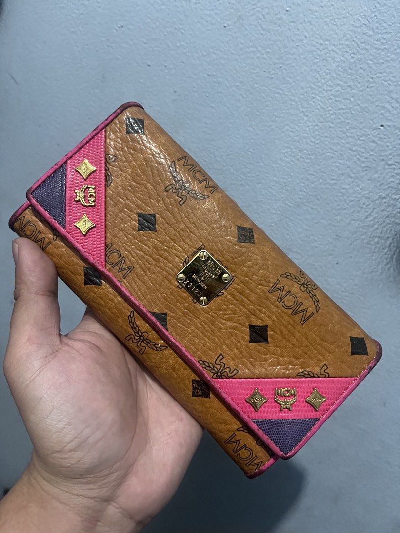 MCM Visetos Wallet Pink Trim (Category: Luxury Bags & Wallets) located in Baguio. Submitted by lattethrift21 (Listing ID 1458904763, Image 1). Description: - Authentic MCM wallet with iconic Visetos monogram pattern - Chic brown exterior with vibrant pink trim - Elegant gold hardware details - Made in Korea - Striking bright pink interior - Minor signs of wear on exterior edges and corners - Interior is clean and well-maintained.