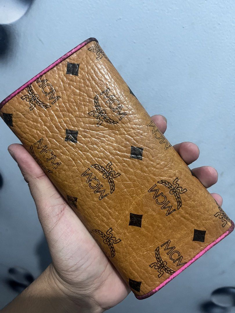 MCM Visetos Wallet Pink Trim (Category: Luxury Bags & Wallets) located in Baguio. Submitted by lattethrift21 (Listing ID 1458904763, Image 3). Description: - Authentic MCM wallet with iconic Visetos monogram pattern - Chic brown exterior with vibrant pink trim - Elegant gold hardware details - Made in Korea - Striking bright pink interior - Minor signs of wear on exterior edges and corners - Interior is clean and well-maintained.