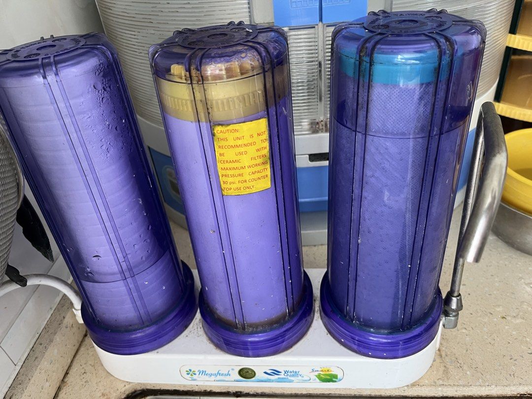 Megafresh Water Filter System with 3 Purple Filter Housings (Category: Water Purifiers & Dispensers) located in Caloocan City. Submitted by wilsonchua88975 (Listing ID 1458992937, Image 1). Description: - Megafresh countertop water filter system - Features three purple filter housings - Middle housing has a yellow caution sticker - Designed for countertop use only - Maximum working pressure: 30 psi - Unit is functional and tested - bought around 