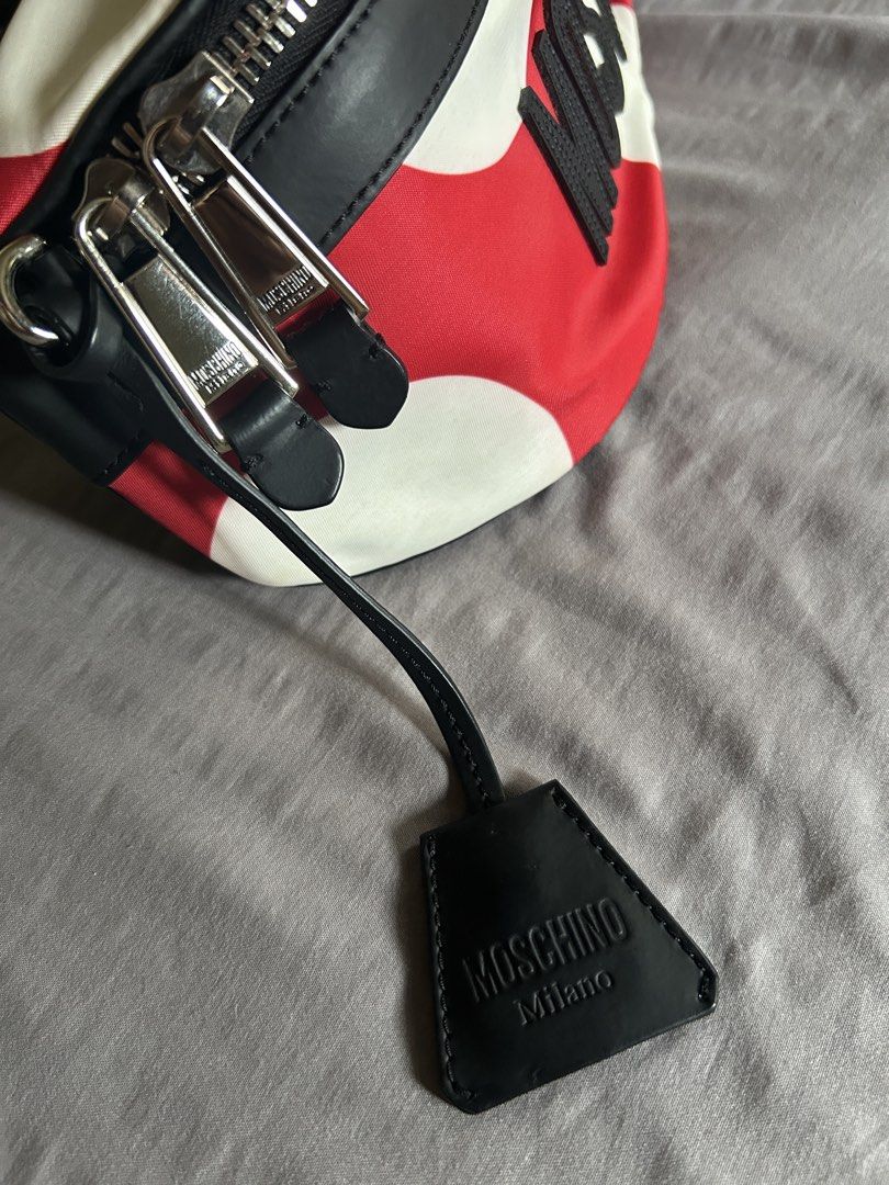 (Authentic) Moschino Red Polka Dot Belt Bag (Category: Luxury Bags & Wallets) located in Carigara. Submitted by abiesclutter (Listing ID 1458934079, Image 2). Description: - Moschino belt bag - Black leather (Calf Skin) trim with red and white polka dots - "MOSCHINO" lettering - Silver hardware and zipper - Adjustable strap - Includes dust bag and authenticity cards - Made in Italy - CERTILOGO AUTHENTICATED with seal.