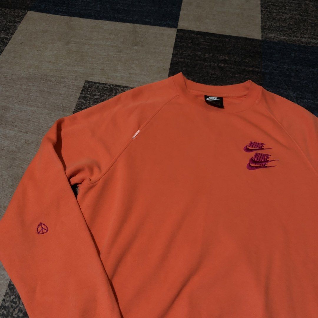 Nike Orange Crewneck Sweatshirt Size M (Category: Coats, Jackets and Outerwear) located in Dasmarinas. Submitted by johnlloydm99208 (Listing ID 1459068624, Image 2). Description: - Orange Nike sweatshirt - Double Nike logo on chest - Peace sign graphic on left sleeve - Made in Pakistan - Tagged size M - Ideal for casual wear.