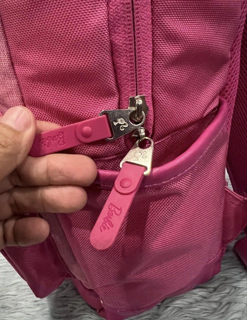 Pink Barbie Backpack (Category: Backpacks) located in Lapu Lapu. Submitted by cecillia07 (Listing ID 1458992715, Image 2). Description: - Adorable pink backpack featuring the iconic Barbie logo. - Multiple compartments and zippers for organized storage. - Padded straps and back ensure maximum comfort. - Perfect for school, travel, or everyday use. - Fun Barbie-themed zipper tags add a special touch. - Protective feet on the bottom to keep it clea