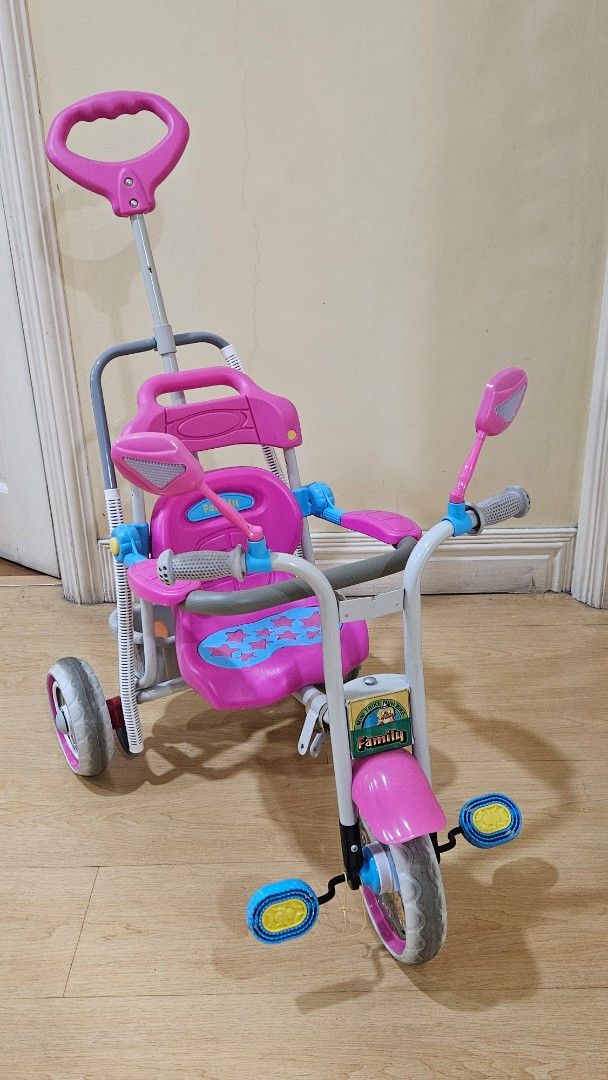 Pink Toddler Tricycle with Parent Handle (Category: Babies & Kids Fashion) located in Paranaque City. Submitted by babythings (Listing ID 1459079349, Image 2). Description: - Pink and grey tricycle perfect for toddlers - Parent push handle for easy steering control - Includes safety bar and footrests for added security - Ideal for outdoor fun and active play - Shows minor scuffs from normal use - Looking for a new loving home!.