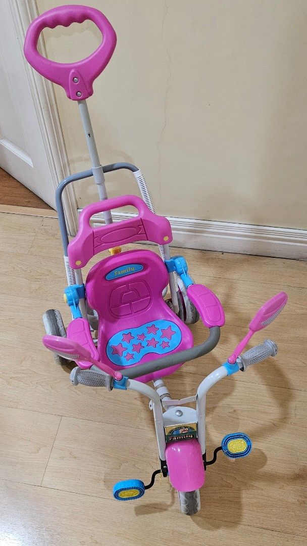 Pink Toddler Tricycle with Parent Handle (Category: Babies & Kids Fashion) located in Paranaque City. Submitted by babythings (Listing ID 1459079349, Image 3). Description: - Pink and grey tricycle perfect for toddlers - Parent push handle for easy steering control - Includes safety bar and footrests for added security - Ideal for outdoor fun and active play - Shows minor scuffs from normal use - Looking for a new loving home!.