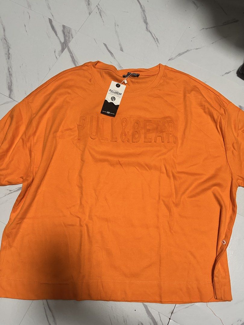 Pull & Bear Orange T-Shirt with Embossed Logo (Category: Shirts) located in Manila. Submitted by tipidfinds888 (Listing ID 1459029043, Image 1). Description: - Brand: Pull & Bear - Color: Orange - Features: Embossed logo on front - Style: Short sleeves, crew neck -boxy type shirt.