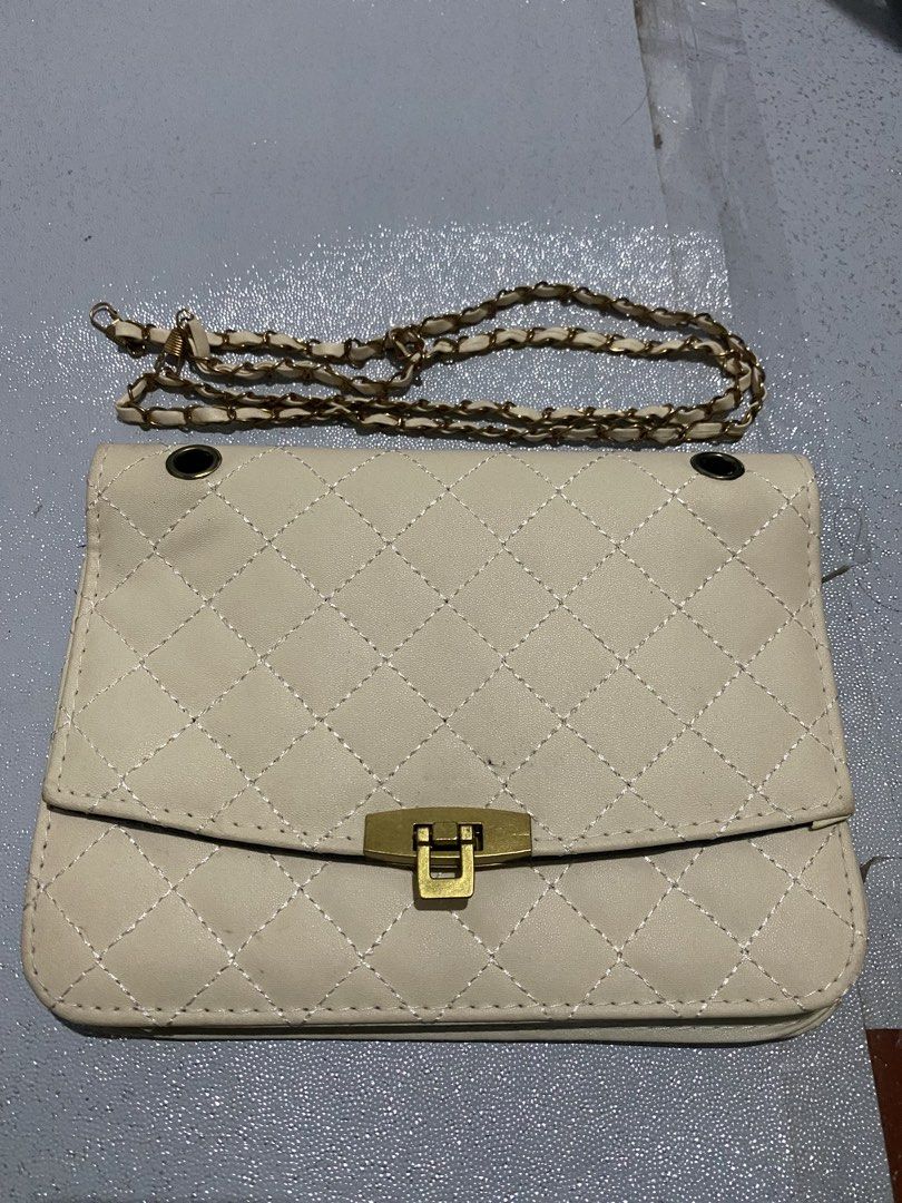 Quilted Chain Shoulder Bag with Gold Clasp (Category: Luxury Bags & Wallets) located in Quezon City. Submitted by wantitkept (Listing ID 1459008474, Image 1). Description: - Cream colored quilted shoulder bag - Features a gold clasp closure on the front flap - Black interior lining - Comes with a detachable gold chain strap - Ideal for going out or everyday use - Fits your essentials.