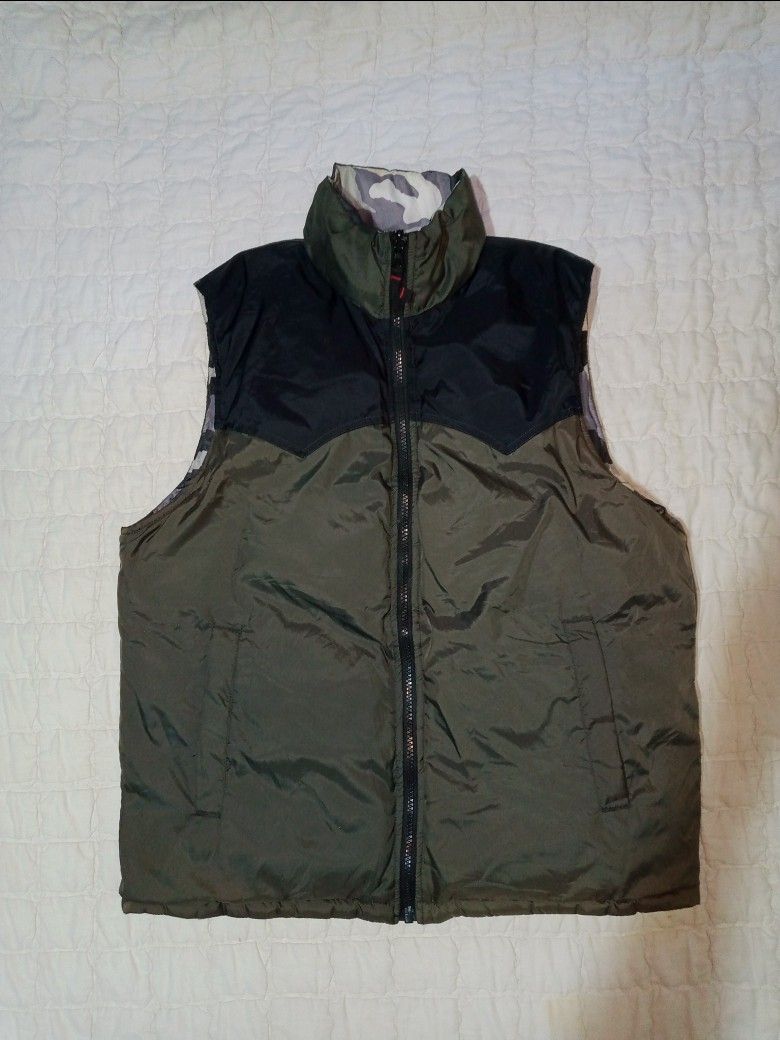 Reversible Camo & Olive Green Puffer Vest (Category: Vests) located in Allen. Submitted by milyonaryung_gipit (Listing ID 1458915605, Image 2). Description: - Super versatile puffer vest - Reversible design: cool grey/black camo print on one side, solid olive green on the other - Stand-up collar for extra warmth - Full front zip closure - Ideal for layering.