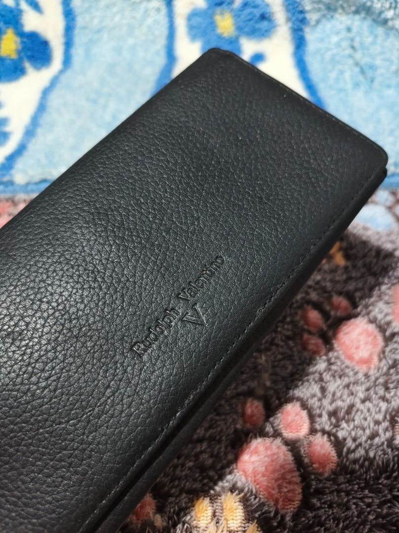 Rudolph Valentino Black Leather Long Wallet (Category: Luxury Bags & Wallets) located in San Leonardo. Submitted by burgossanleonardo.12345 (Listing ID 1458918768, Image 1). Description: - Genuine Rudolph Valentino black leather long wallet - Ample card slots and compartments for organization - Secure zippered section for valuables - Timeless, classic design - Ideal for everyday use.