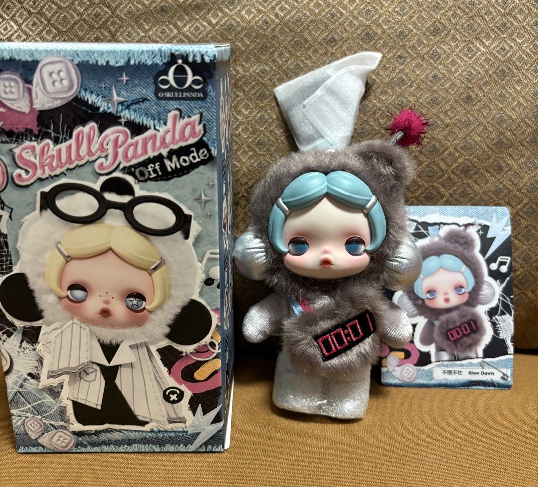 Skull Panda Off Mode Slow Down Plush Pendant (Category: Designer & Blind Box Toys) located in Manila. Submitted by champsey (Listing ID 1458905169, Image 2). Description: - Pop Mart Skull Panda Off Mode Series Plush Doll Pendant - Character: Slow Down (never been used) - Includes original box and character card - Figure details: Fuzzy grey outfit, blue hair, digital display on front - Ideal for collectors and fans of Skull Panda - Delivery fees c