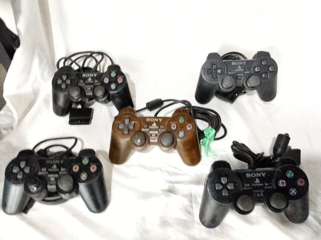 Sony PlayStation DualShock 2 Controllers (5x) (Category: PlayStation) located in Quezon City. Submitted by jpnvintageonline (Listing ID 1458904909, Image 3). Description: - 5 Sony PlayStation DualShock 2 controllers - 1 Brown controller, 4 Black controllers - All controllers include cords - Some controllers feature rumble function - Ideal for multiplayer gaming sessions - Bundle deal available.