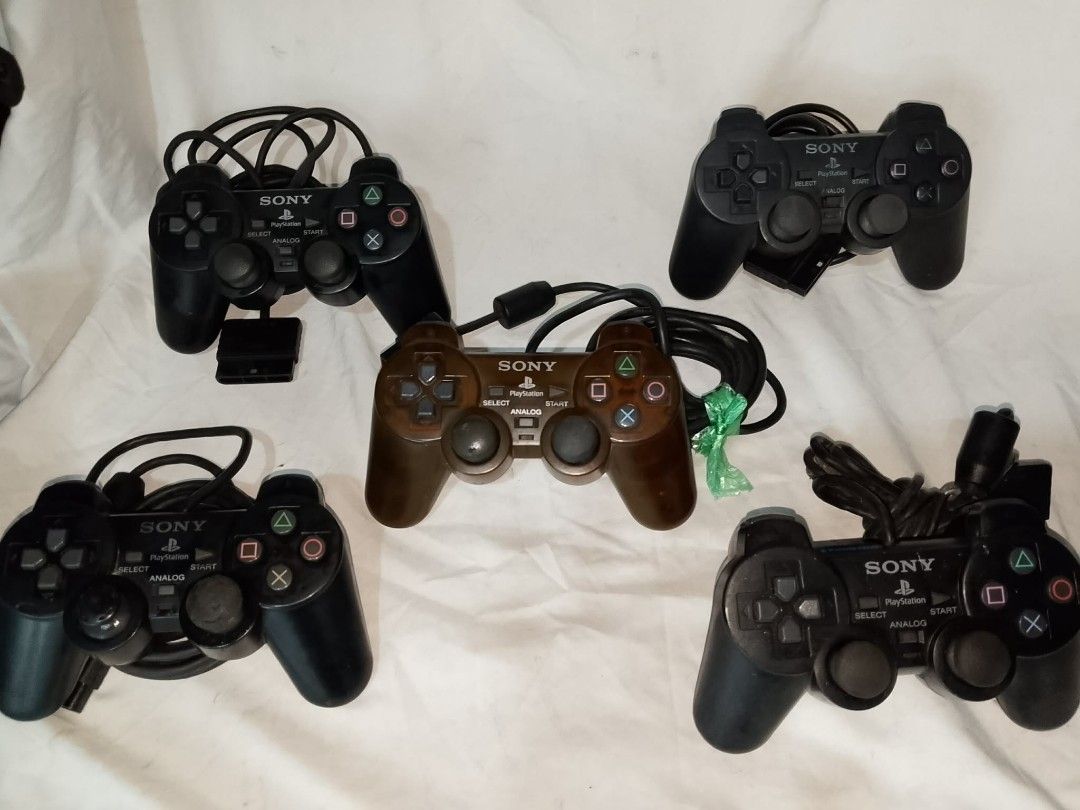 Sony PlayStation DualShock 2 Controllers (5x) (Category: PlayStation) located in Quezon City. Submitted by jpnvintageonline (Listing ID 1458904909, Image 1). Description: - 5 Sony PlayStation DualShock 2 controllers - 1 Brown controller, 4 Black controllers - All controllers include cords - Some controllers feature rumble function - Ideal for multiplayer gaming sessions - Bundle deal available.