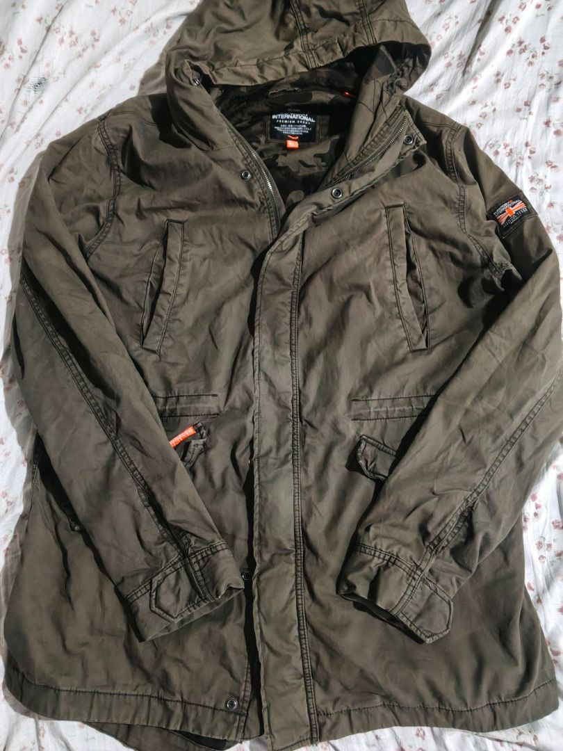 Superdry International Military Jacket (Category: Coats, Jackets and Outerwear) located in Caloocan City. Submitted by nebs_seller (Listing ID 1458894807, Image 1). Description: - Superdry International Jacket - Color: Olive Green - Size: 2XL - Camouflage lining with 'The Rookie Super Dry' print - Hooded design - Multiple pockets - Ideal for casual wear.