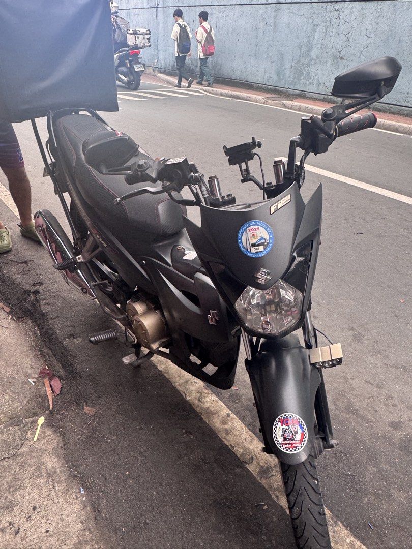 Suzuki Raider J 115 Fi Motorcycle (Category: Motorbikes for Sale) located in Manila. Submitted by sheinevida (Listing ID 1459040255, Image 1). Description: Suzuki Raider J 115 Fi. Matte black finish Jan 2017 model Has a phone mount on the handlebars. Can include used Evo helmets 1 modular and fullface Great for deliveries or daily commute service First owner here❤️ Registered Until FEB 2027 Well maintained sa change oil. Tipid sa Gas consumption.