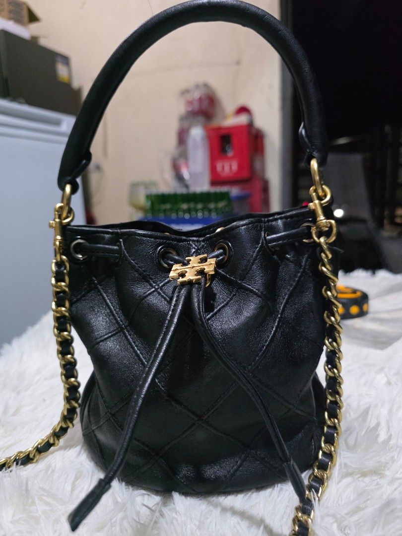 Tory Burch Soft Fleming Black Leather Bucket Bag (Category: Cross-body Bags) located in Lemery. Submitted by venus23 (Listing ID 1458990972, Image 1). Description: - Elegant black leather bucket bag - Stylish quilted pattern - Luxurious gold chain strap - Convenient top handle - Secure drawstring closure - Signature Tory Burch logo hardware - Interior includes a green box - Compact size: approximately 6 inches wide.