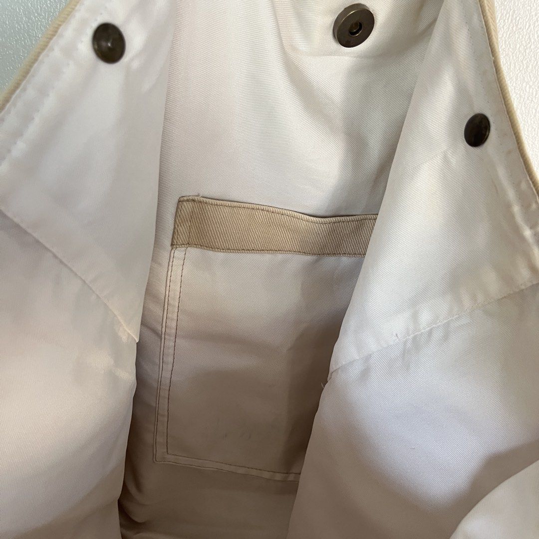 Tote & Beyond Beige Canvas Tote Bag (Category: Tote Bags) located in Las Pinas. Submitted by solfits (Listing ID 1458899169, Image 3). Description: - Simple beige canvas tote bag - Snap closure at the top - Interior pocket for essentials - Minor marks on inside lining - Tiny dark speck on exterior fabric.