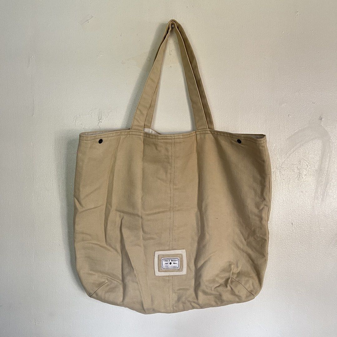Tote & Beyond Beige Canvas Tote Bag (Category: Tote Bags) located in Las Pinas. Submitted by solfits (Listing ID 1458899169, Image 1). Description: - Simple beige canvas tote bag - Snap closure at the top - Interior pocket for essentials - Minor marks on inside lining - Tiny dark speck on exterior fabric.