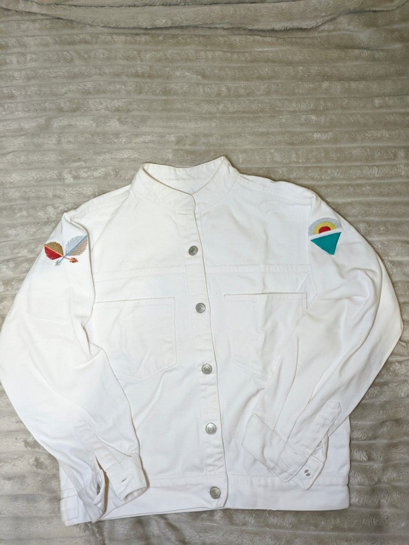 White Denim Jacket with Embroidered Patches (Category: Coats, Jackets and Outerwear) located in Taguig. Submitted by mysticstorm.d7d18e (Listing ID 1458931548, Image 1). Description: - Classic fit white denim jacket - Button-up front closure - Two chest pockets - Button cuffs on sleeves - Two embroidered patches on front left chest - One embroidered patch on left sleeve.