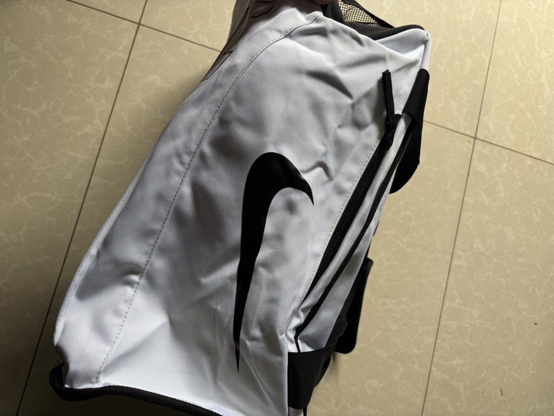 White Nike Backpack with Large Logo (Category: Backpacks) located in Quezon City. Submitted by nojthrift (Listing ID 1459043933, Image 2). Description: - White Nike backpack - Large Nike logo on front - Smaller Nike swoosh on side - Black trim and straps - Spacious interior - Ideal for school or gym use 1350.