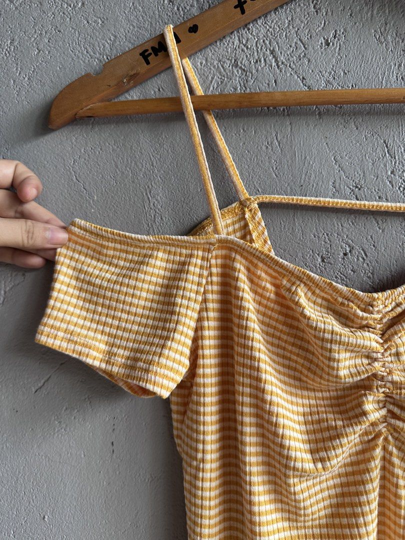 Yellow Gingham Cold Shoulder Ruched Crop Top (Category: Blouses) located in Binan City. Submitted by forgetmenot_ph (Listing ID 1458996656, Image 3). Description: - Cute yellow and white gingham pattern - Ruched front detail - Cold shoulder sleeves - Thin spaghetti straps - Ribbed fabric texture - Pairs well with high-waisted jeans or shorts - Ideal for casual outings and summer vibes.